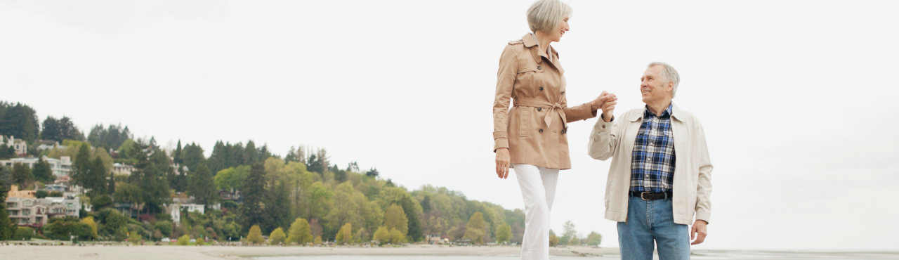 man assisting woman walking on driftwood